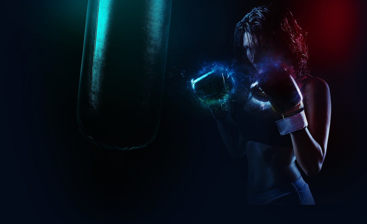 A boxer working a heavy bag under violet and teal light