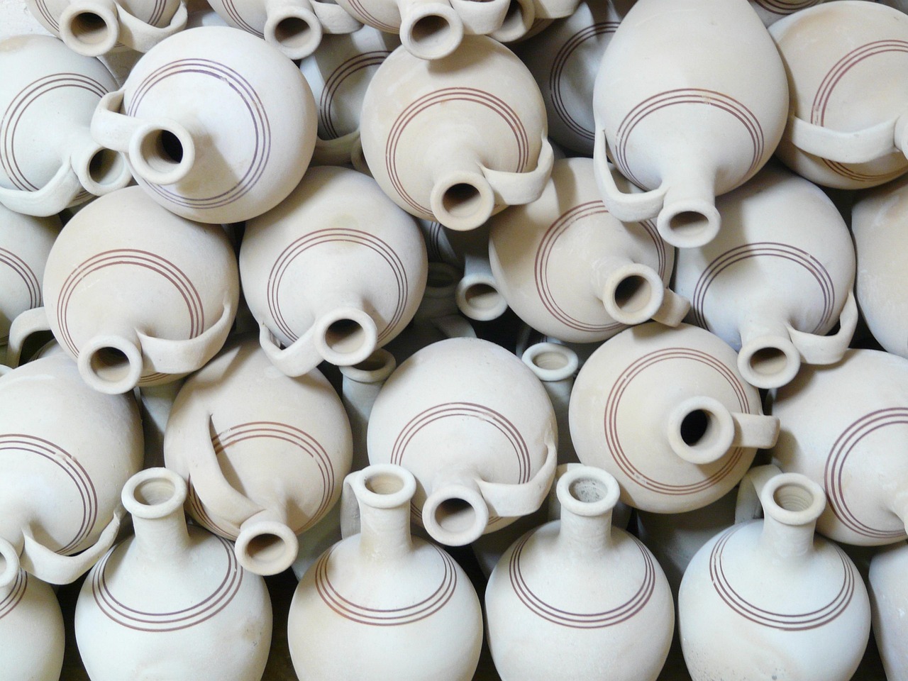 Rows of bisque-fired jugs waiting for glaze