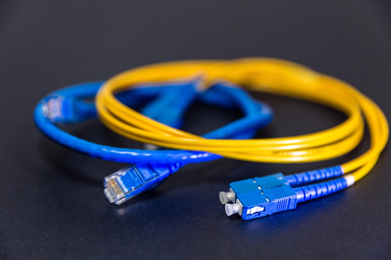 Fibre and ethernet cables coiled on dark