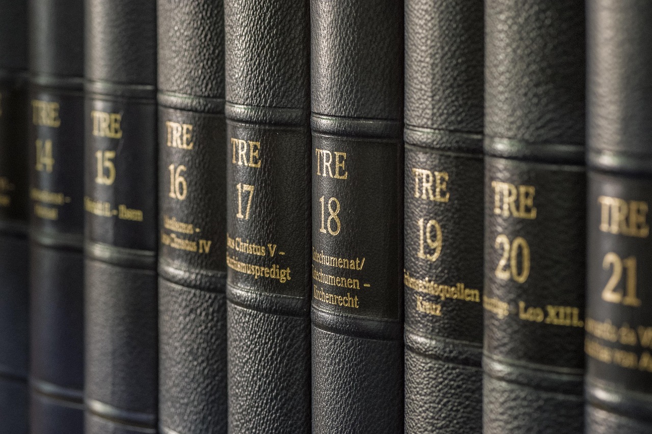 Dark leather book spines with gold numbering on a library shelf