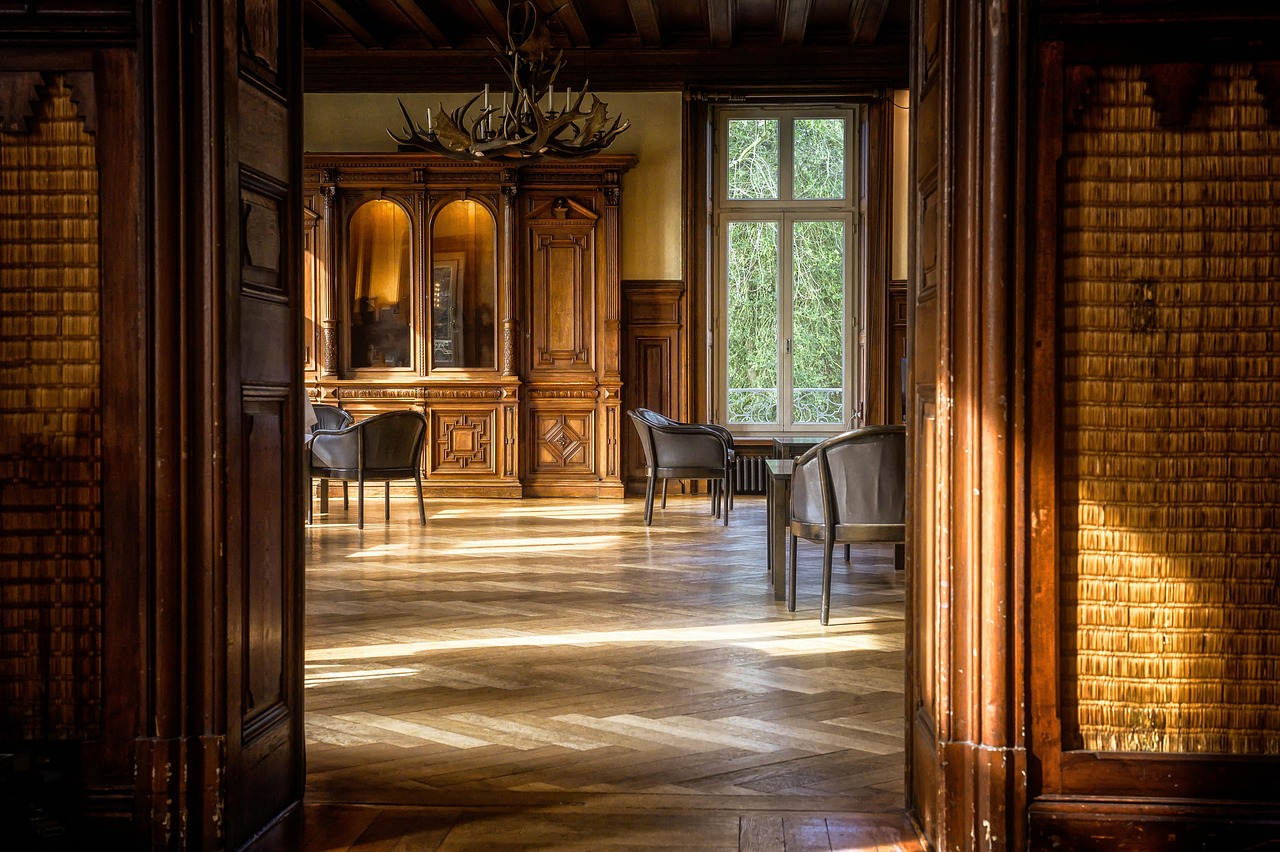 A manor room with herringbone parquet in afternoon sun