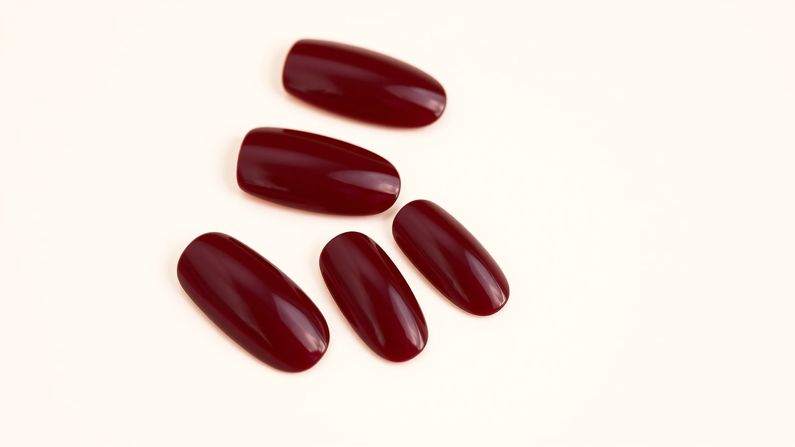 Macro of deep cola-red gel nails with a wet-look topcoat