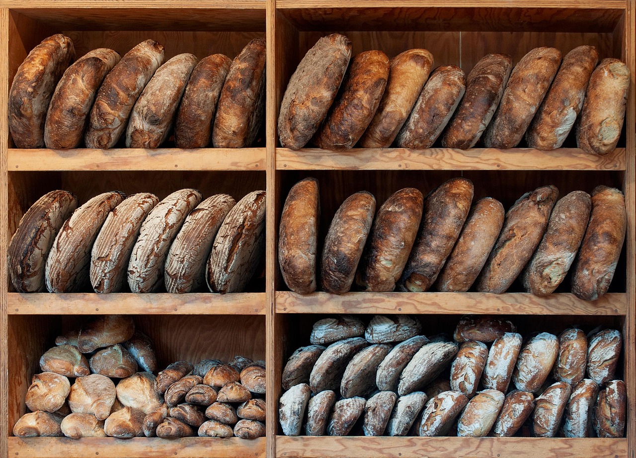 Wooden shelves stacked with dark-crusted loaves