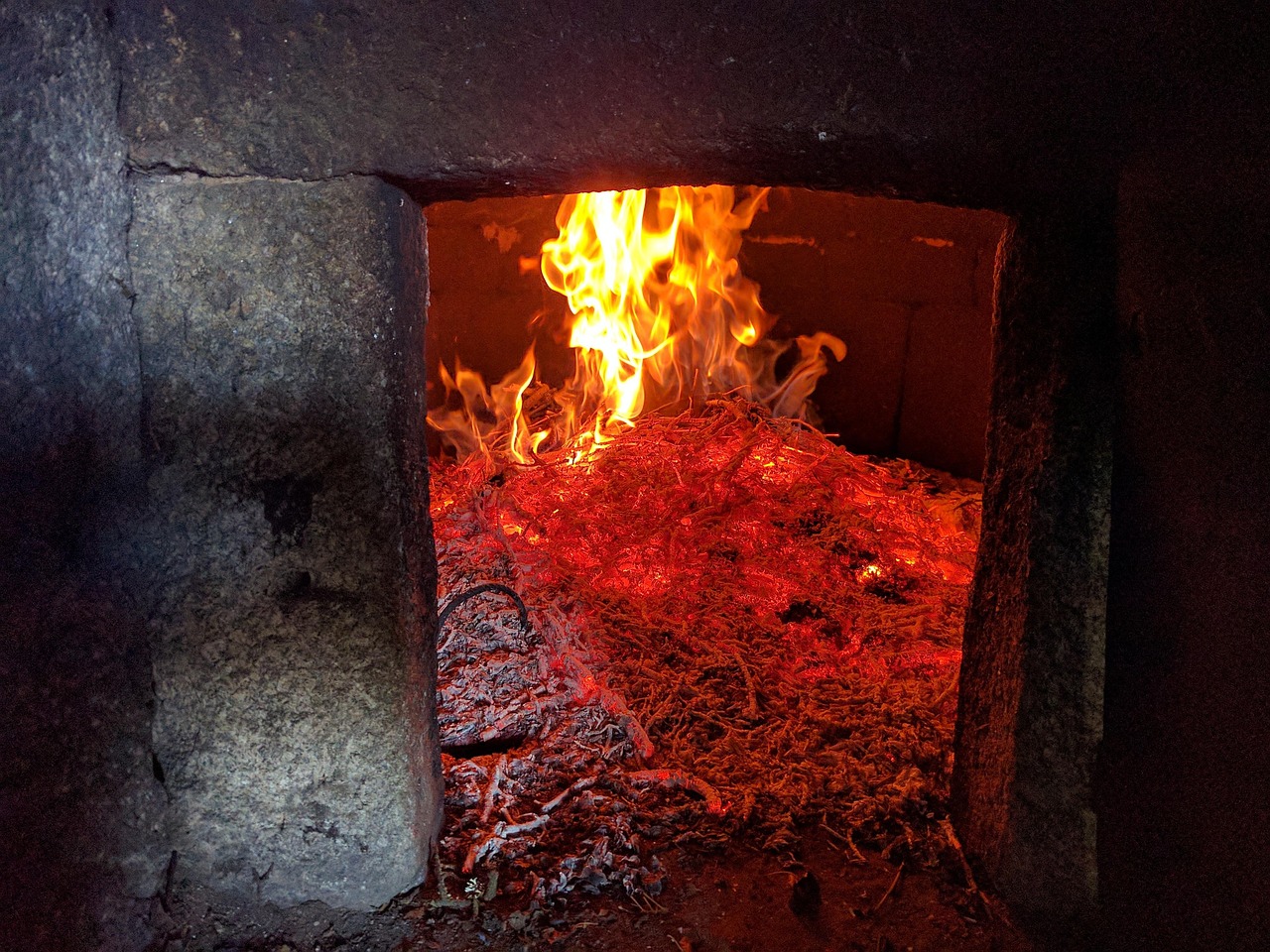 The glowing mouth of a wood-fired kiln