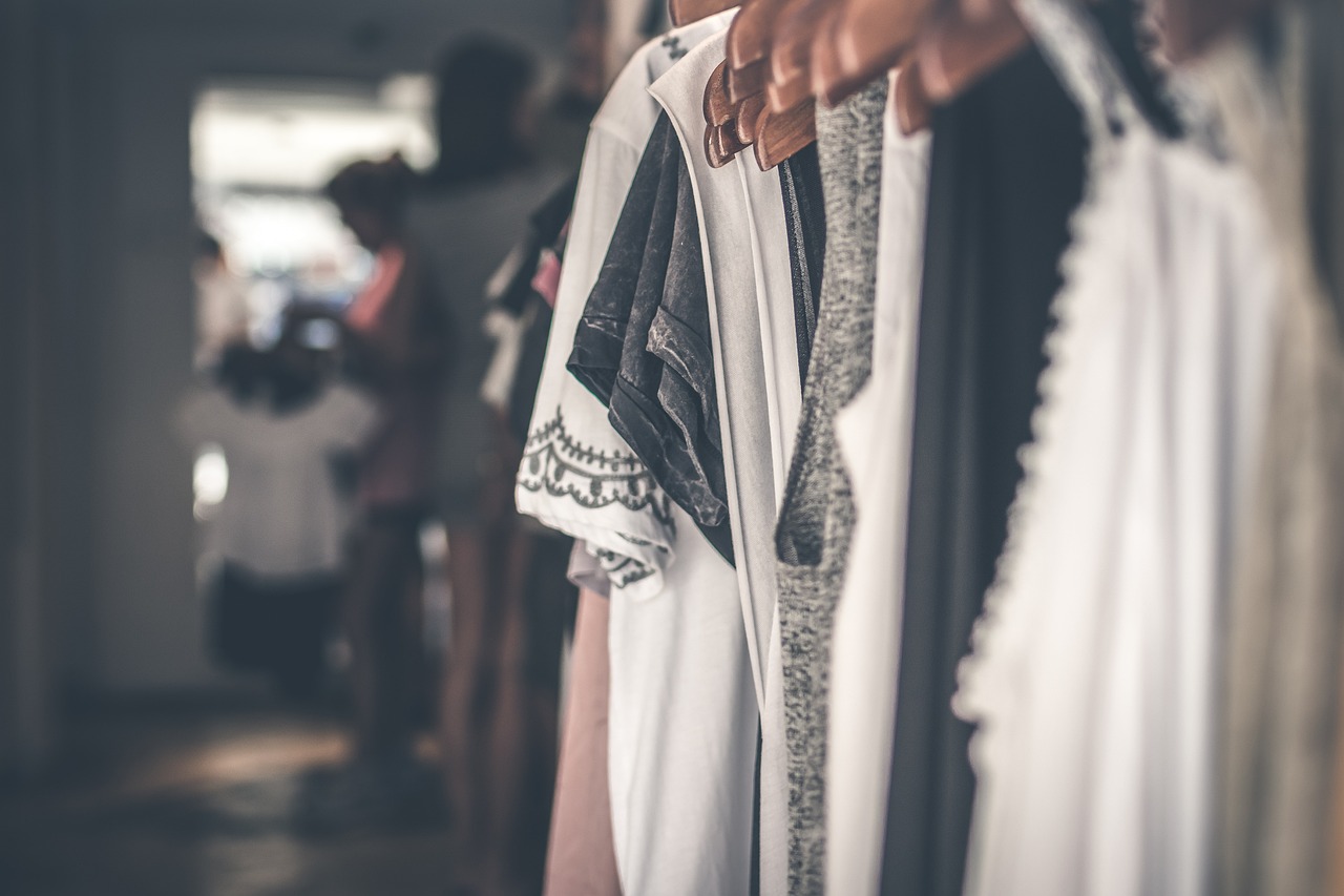 Pale garments hanging on a rail in low light