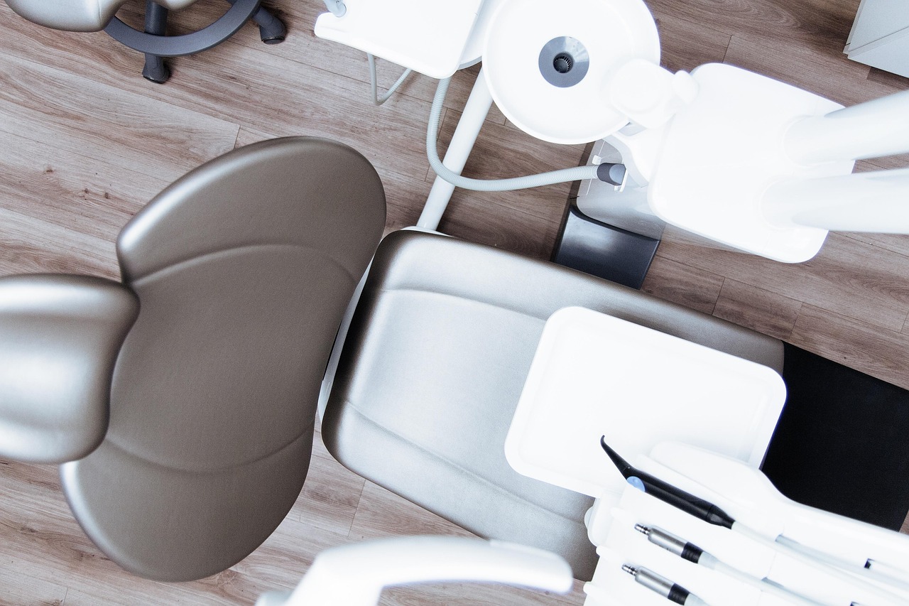 A modern dental chair seen from above, warm wood floor, soft light