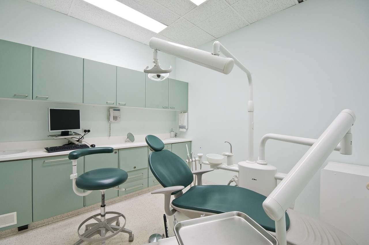 A calm mint-green treatment room, chair waiting in soft light