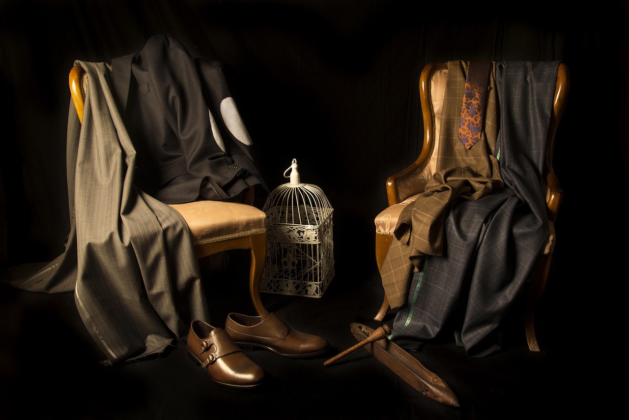 Draped suiting cloth and monk-strap shoes in low light