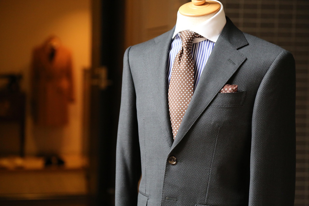 A half-finished bespoke jacket on a tailor's form in warm workshop light