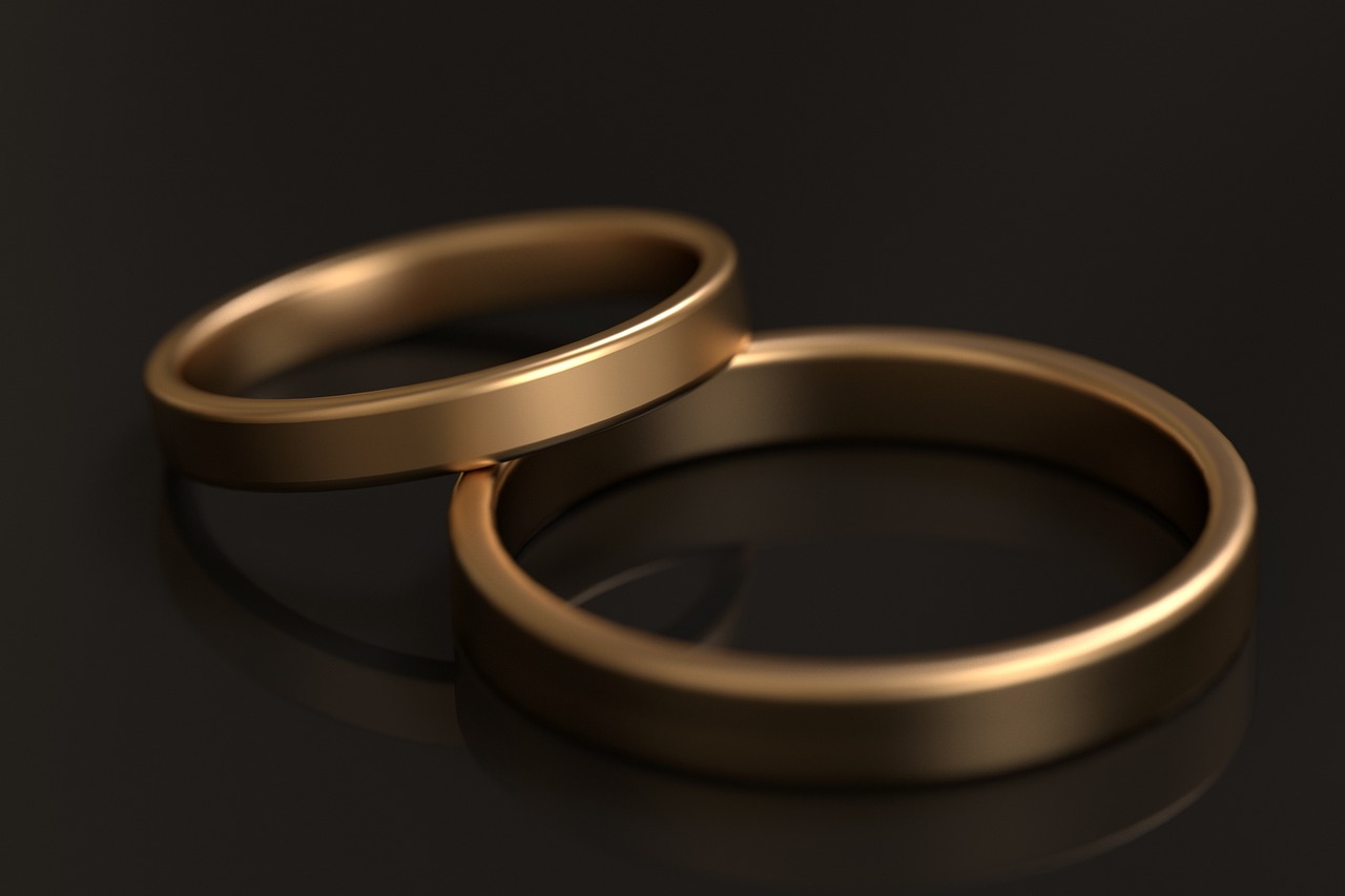 Two plain gold bands resting together on dark velvet