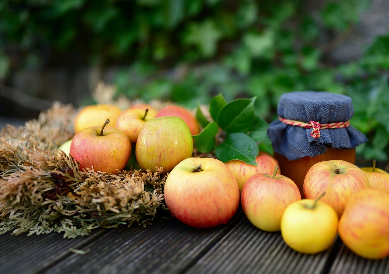 Orchard apples beside a cloth-topped jar of preserve