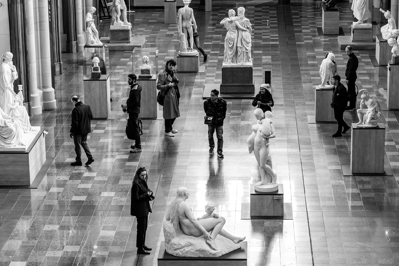A sculpture hall of classical marbles with visitors