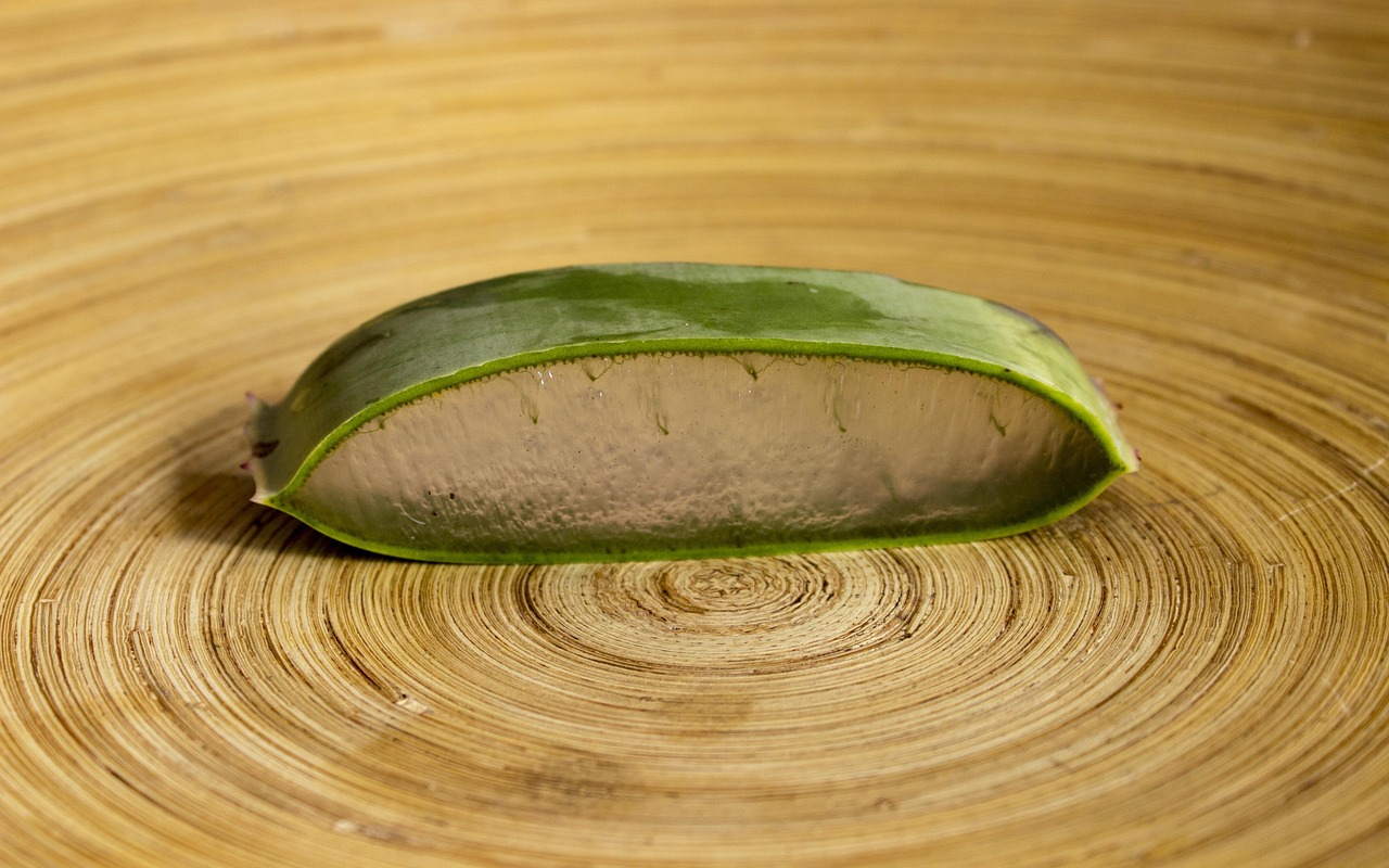 A cut aloe leaf on a spun bamboo board