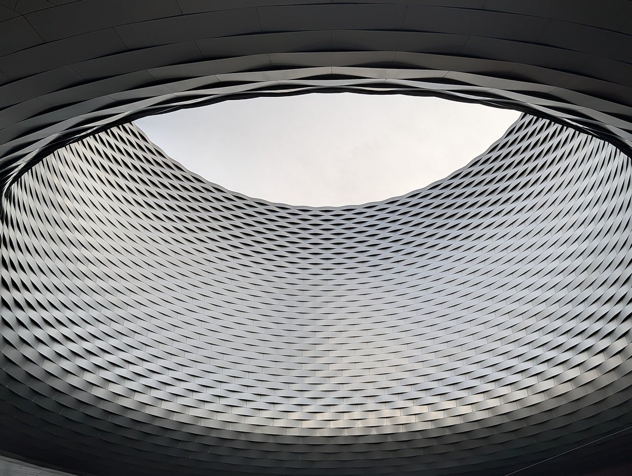 The woven metal facade of Messe Basel, seen from below