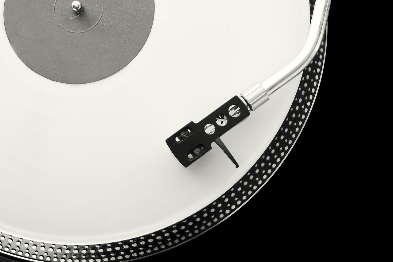 A white LP under a tonearm on black