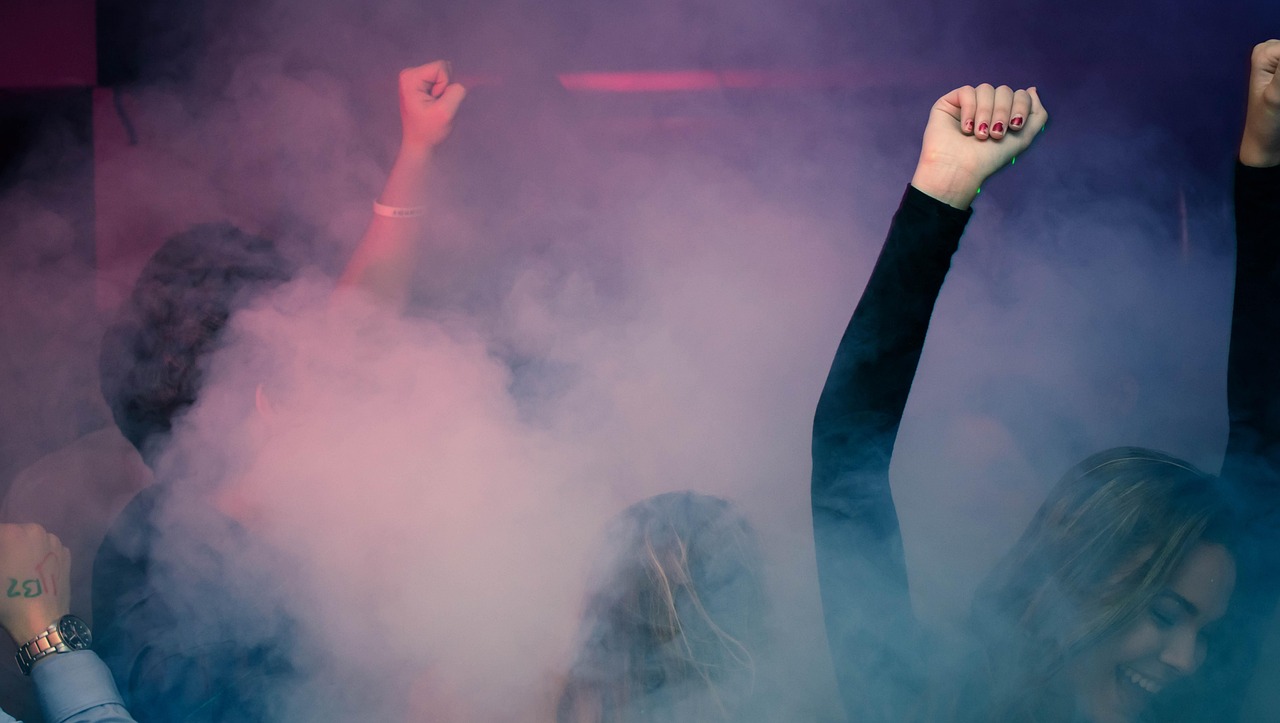 Raised fists in pink-purple smoke